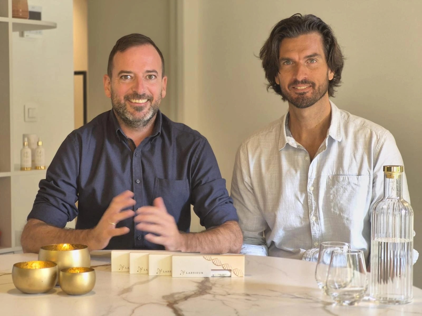 Os fundadores da Labbieux sentados juntos à mesa, a sorrir para a câmara